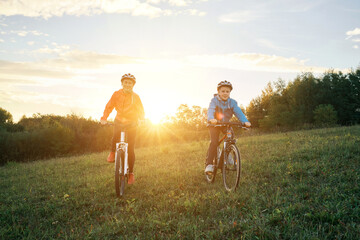 Happy family outdoors, Mother and son ride a bike. Happy cute boy in helmet learn to riding a bike...