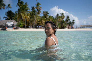 Beautiful tan Colombian women in crystal Caribbean sea water in San Blas Palm tree Islands, Panama