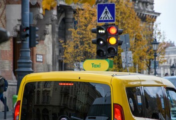 Closeup shot of a yellow taxi car under the traffic lights on a street of an urban city