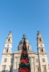 Obraz premium Low angle shot of Saint Stephen's Basilica and a Christmas tree in front of it in Budapest