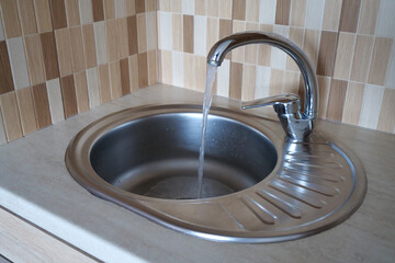 Water pours in a strong stream from the tap in kitchen