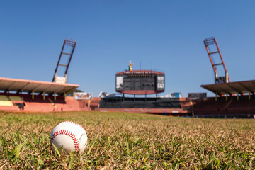baseball on the base with the bat to the side in the background of the stadium