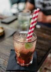 Cocktail with ice, mint, and striped straws