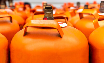 Close up of portable orange refilling gas cylinders in transportation car.