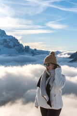 Caucasian woman wearing warm cloth standing in front of snow covered mountain