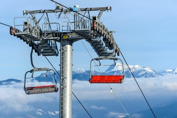 Empty ski lift in a ski resort with a beautiful view of snowy mountains in the background