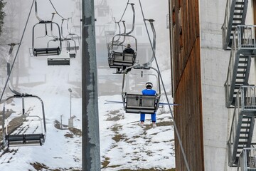 Ski resort with people enjoying rides on ski lifts on a misty winter day