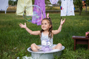 Fun kid fun. Washing in the fresh air. A child is playing in the garden. Little hostess. A little...
