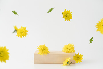 Wooden podium background with flying yellow flowers on  white background. Stand mockup for cosmetic...