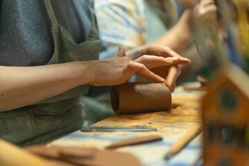 Close up of human hands making a clay mug. Pottery teaching class. Potter makes dishes from clay, ceramics.