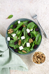 Beetroot salad with feta cheese, chard and walnuts on a pink background. Top view. 