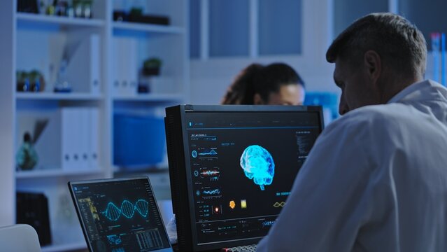 Medical laboratory scientist studying patient's brain mri on computer, diagnostics