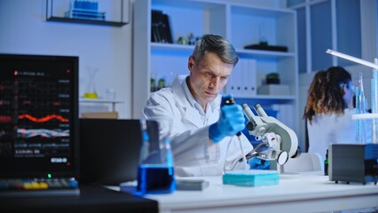 Molecular chemistry lab scientist examining liquid under microscope, research