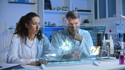 Laboratory scientists looking at infected cell mutation, discussing experiment results