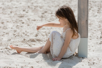 happy little girls play on a white sandy beach near the ocean in summer. Children's holidays. Earth Day. Children's Day.Space for text