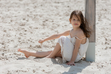 happy little girls play on a white sandy beach near the ocean in summer. Children's holidays. Earth...