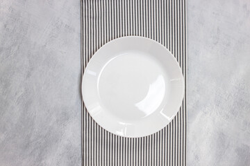 Empty plate on tablecloth on marble table