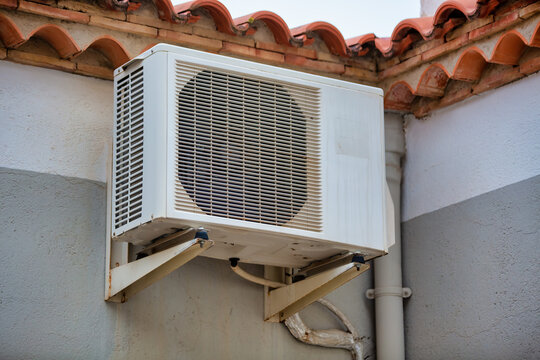 Exterior view of split air conditioner unit installed on house wall