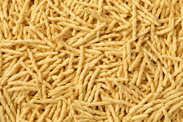 Dried Italian trofie pasta close up full frame as background