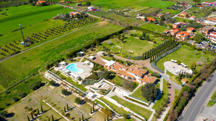 Aerial view of a large Italian farmhouse with a swimming pool. There is nobody in this period and the hotel is empty.