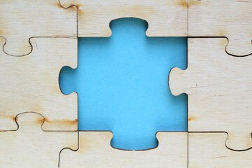 Incomplete and absence wooden puzzle piece with blue backdrop. Missing piece. Mental health concept. Symbol of problem solving. Business creative solution. Communication idea. Hobby, play, fun game