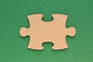 Carton mosaic game detail of jigsaw puzzle element on green background. Completing task or solving problem concept. World mental health day, autism awareness day. Global communication. Hobby, play