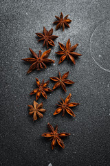 Fragrant anise stars on a black background. Spices and condiments. On a textured background.