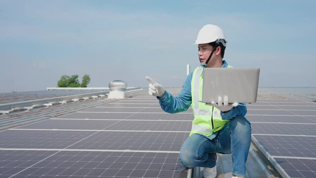 Asian Engineer Man counting amount panel of solar and record data in laptop on roof top at factory, Annual Maintenance concept