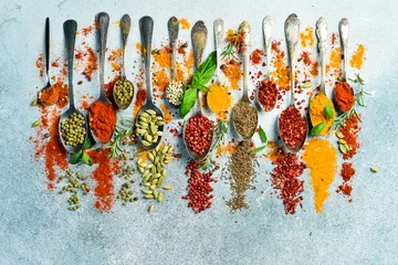 Crédence de cuisine Cuisine Spices and herbs in spoons on a gray stone background. Top view. Free space for text.  © Yaruniv-Studio