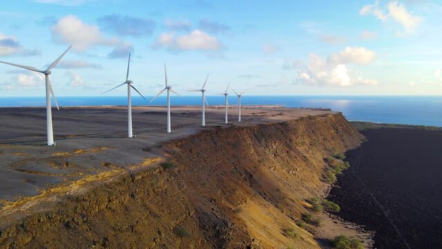 Aerial shot of a row of wind turbines near the ocean in Hawaii