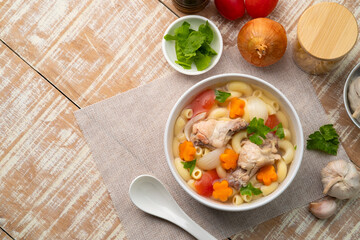 Macaroni Soup with drumette chicken ,tomato ,carrots and onion ,easy asian style clear soup in white bowl