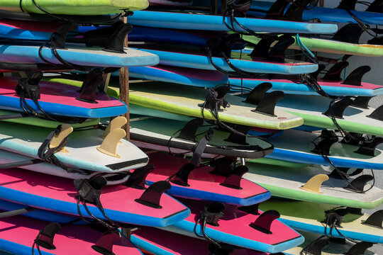 Multicolored surfboards  in stock for rent near the sea on the beach. different colors surfing boards on rack stand