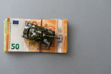 Toy military tank on the background of Euro banknotes