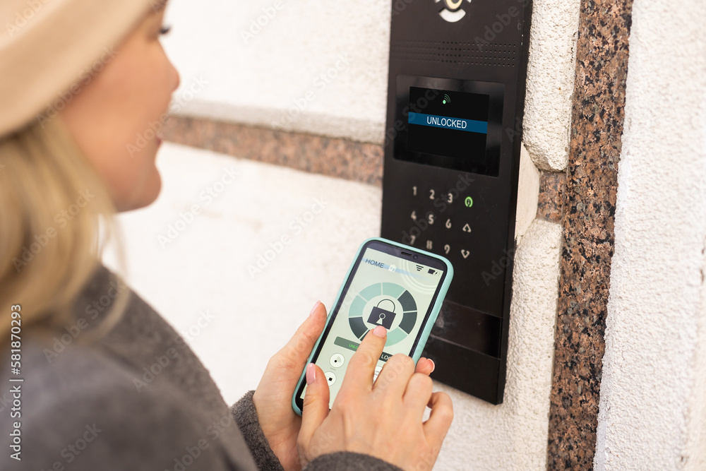 Aufkleber smiling woman setting home security system with help of mobile application.