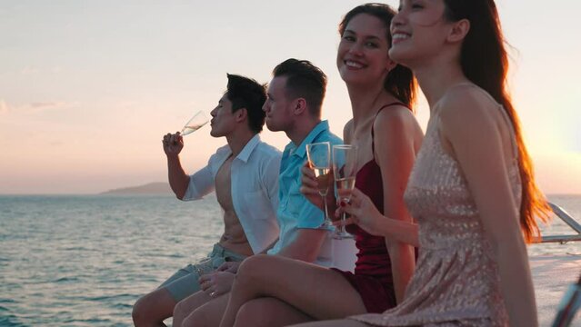 Group of business friends together celebrating and enjoying party with drinking champagne sitting at prow on yacht, Outdoor lifestyle of the sea and travel vacation concept