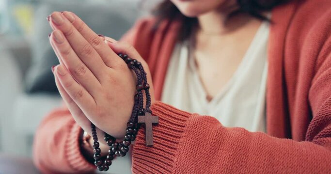 Christian woman, rosary and hands praying in home of spiritual faith, holy gospel and worship God. Closeup female, prayer beads and cross for religion, mercy and praise lord of jesus, heaven or peace