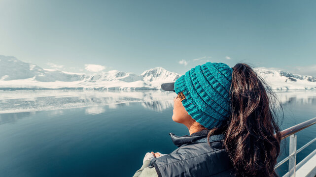 Female Tourist On Luxury Antarctica Cruise Ship Looking Out At The Stunning Scenic Arctic Landscape, In Awe
