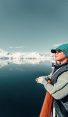 Female Tourist On Luxury Antarctica Cruise Ship Looking Out At The Stunning Scenic Arctic Landscape