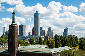 Fototapeta premium skyscraper skyline citiscape in Rotterdam, Netherlands on sunny summer day. Impressive high building shows unique modern architecture in Dutch city centre with green trees for quality nature