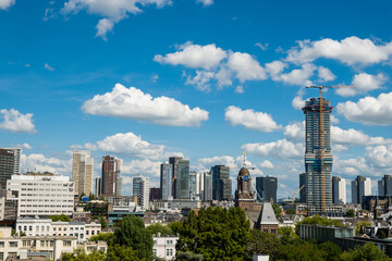 skyscraper skyline citiscape in Rotterdam, Netherlands on sunny summer day. Impressive high building shows unique modern architecture in Dutch city centre with green trees for quality nature