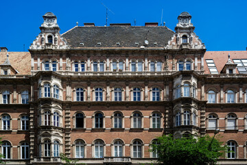 Old red brick building with a mezzanine on the roof in the city of Budapest in Hungary.