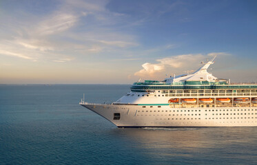 Fototapeta na wymiar Luxury cruise ship sailing from port on sunrise 
