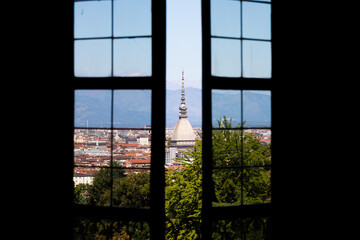 Fototapeta premium Turin - Italy - Urban skyline with Mole Antonelliana building, blue sky and Alps mountains.