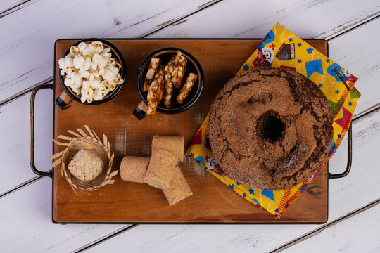 wooden tray with cake, popcorn, paçoquinha and pé de moleque - June party