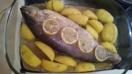 The process of cooking trout fish with potatoes and lemon