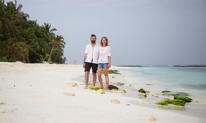 happy couple on tropical beach pastel colors