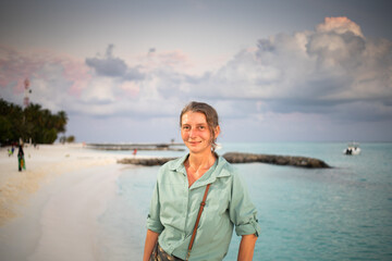 Fototapeta premium woman looking at pink sunset over tropical sea freedom