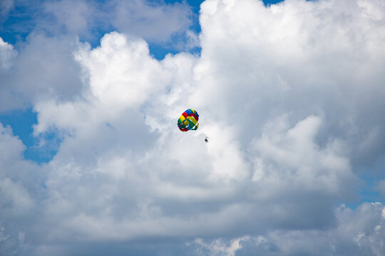 parasailing against blue sky rainbow colors
