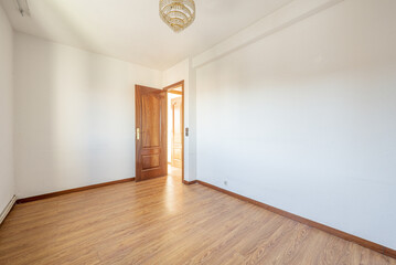 Empty room with wooden laminate flooring, ceiling lamp with crystals and sapele wood doors