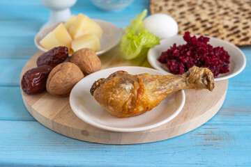 Symbolic meal for Passover (Pesach) Seder Plate on wooden background. Shank bone on the background of traditional Pesach food. 